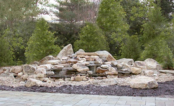 Multi-tiered rock water feature built with slabs, boulders and river rock. Feature is approx. 32 ft. across.