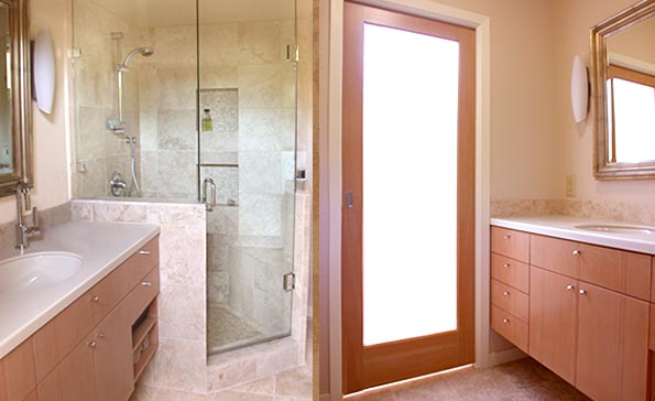 Douglas fir built-in cabinets, a pocket door with translucent panel, and a travertine tiled shower enclosure give this 1950’s-era bathroom a warm and contemporary look.