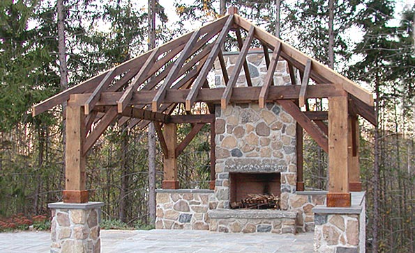 Timber frame structure built around stone fireplace; built with 100 year-old reclaimed barn lumber.